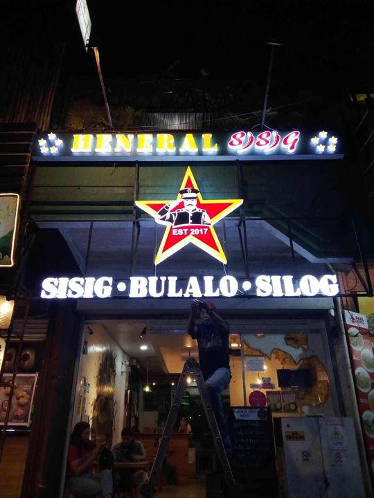 Heneral Sisig lit star and acrylic letters at night