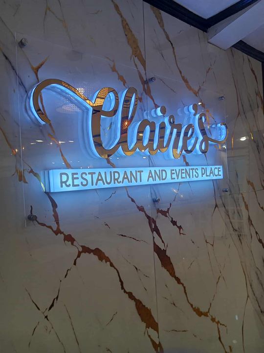 Claire's Restaurant back-lit gold acrylic sign on marble