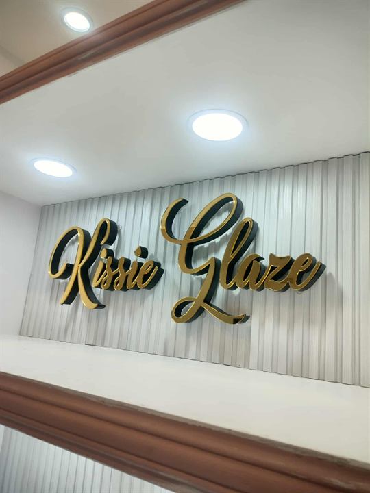 Kissie Glaze gold script letters on a wall