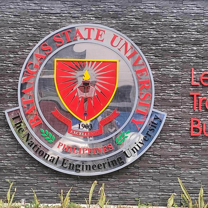 Batangas State University seal on a brick wall